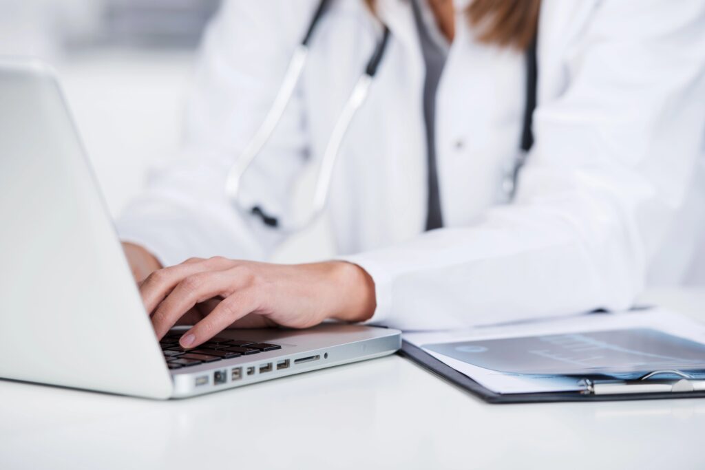 woman working on a computer to manage clinical trial data